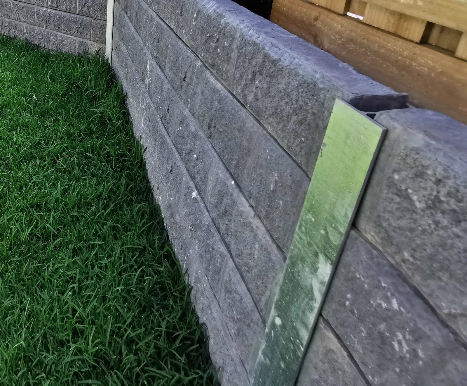 Concrete sleepers slotted between steel posts forming a retaining wall system